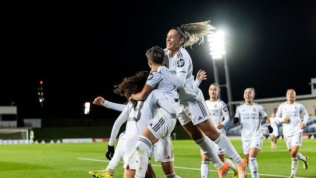 Las jugadoras del Real Madrid Femenino celebran efusivamente un gol en el campo.